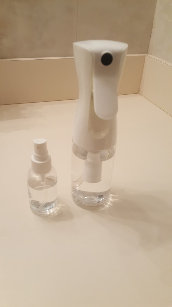 Two spray bottles side by side for the analogy of how we apply kindness either lavishly or in a stingy manner
